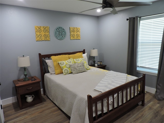 bedroom with dark hardwood / wood-style flooring and ceiling fan