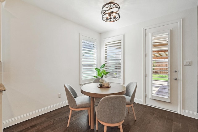 dining room featuring a chandelier, a wealth of natural light, and dark wood-type flooring