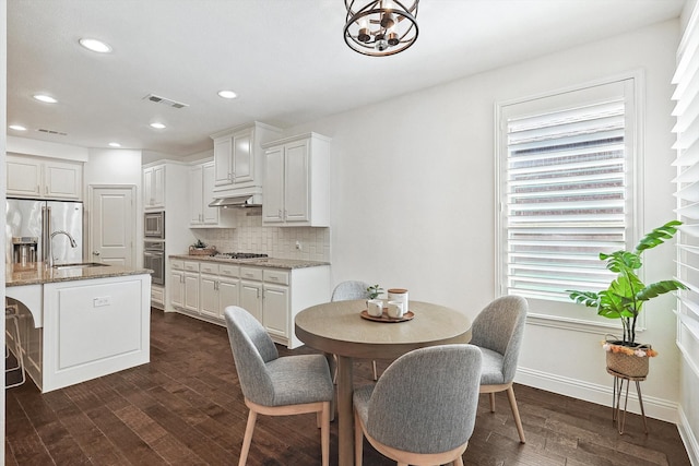 dining space with dark hardwood / wood-style flooring and sink