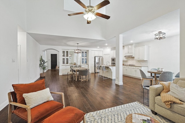 living room featuring ceiling fan, sink, and dark wood-type flooring