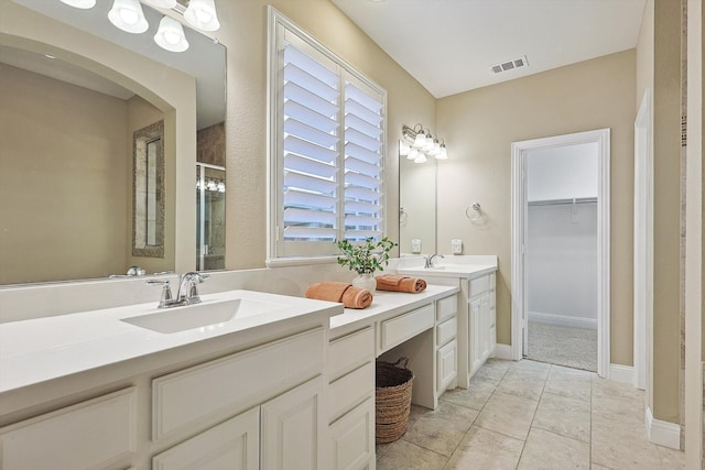 bathroom featuring tile patterned floors, vanity, and a shower with door