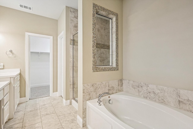 bathroom featuring tile patterned floors, vanity, and shower with separate bathtub