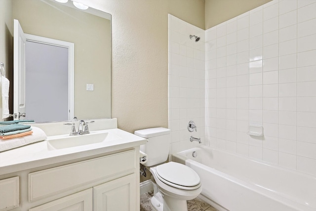 full bathroom with tiled shower / bath, vanity, and toilet