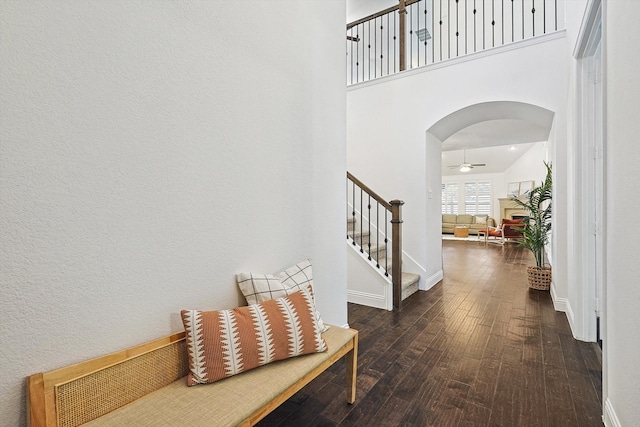 entrance foyer featuring dark hardwood / wood-style floors, ceiling fan, and a towering ceiling