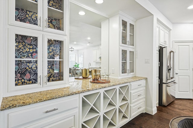 bar featuring dark hardwood / wood-style flooring, white cabinetry, high quality fridge, and light stone counters