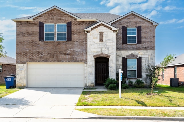 view of front of property with cooling unit, a garage, and a front yard