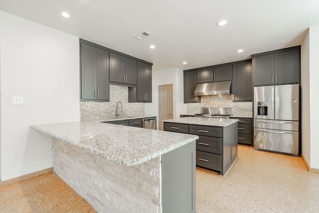 kitchen with a breakfast bar, sink, kitchen peninsula, backsplash, and appliances with stainless steel finishes