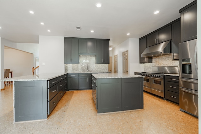 300 Turtle Ct, Mckinney, TX 75072 - kitchen featuring a peninsula, light stone countertops, a center island, under cabinet range hood, and appliances with stainless steel finishes