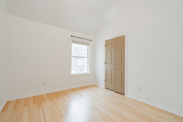 unfurnished room featuring lofted ceiling and light hardwood / wood-style floors