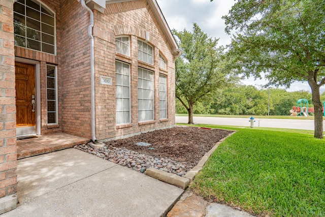 entrance to property featuring a lawn