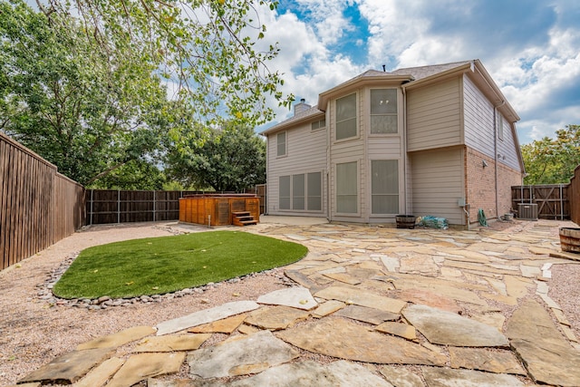 rear view of house featuring central AC unit and a patio area