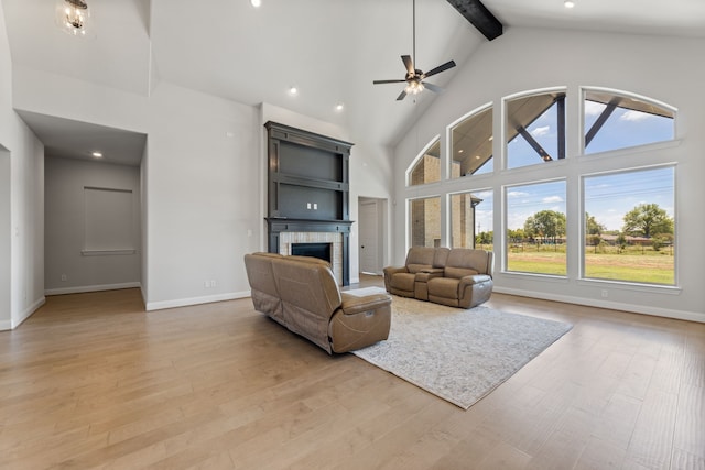 living room featuring high vaulted ceiling, light hardwood / wood-style flooring, and a fireplace