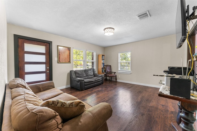 living room featuring dark hardwood / wood-style floors and a textured ceiling