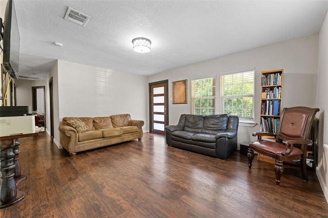 living room featuring a textured ceiling and dark hardwood / wood-style floors