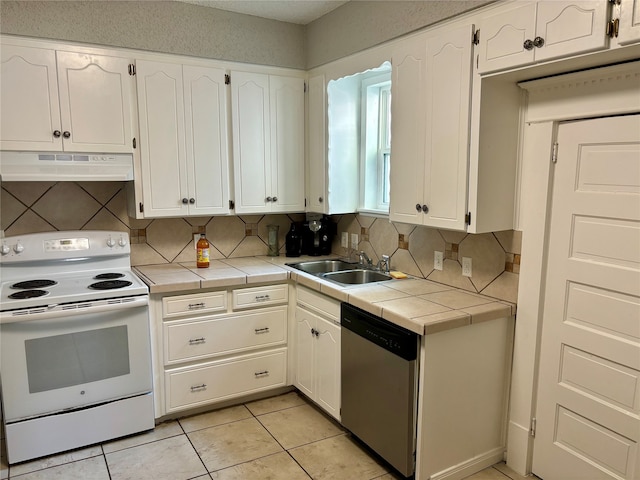 kitchen featuring dishwasher, tile counters, sink, white range with electric stovetop, and white cabinets