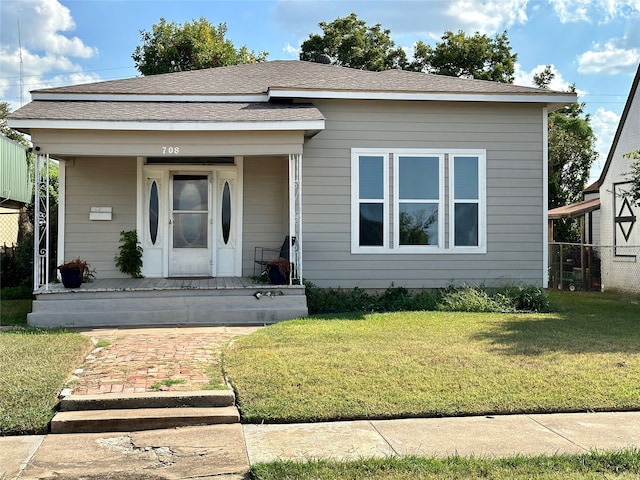 view of front of home with covered porch and a front lawn