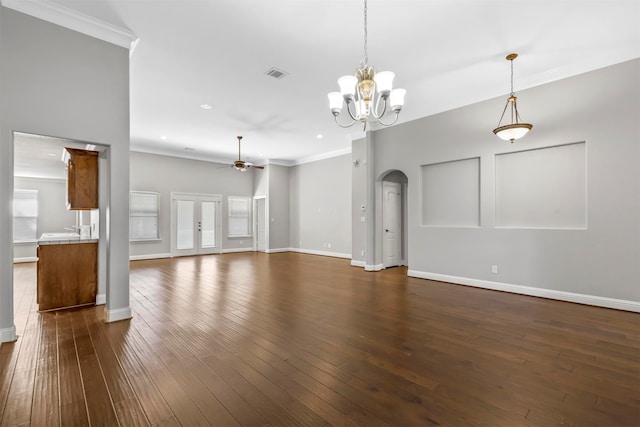 unfurnished living room featuring ceiling fan with notable chandelier, crown molding, and dark hardwood / wood-style flooring