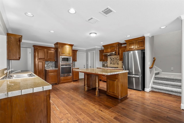 kitchen with appliances with stainless steel finishes, decorative backsplash, a breakfast bar area, and dark hardwood / wood-style floors