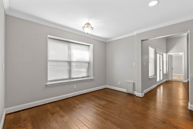 spare room featuring crown molding and dark hardwood / wood-style flooring