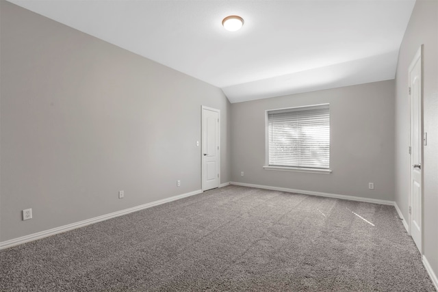 spare room featuring lofted ceiling and carpet flooring