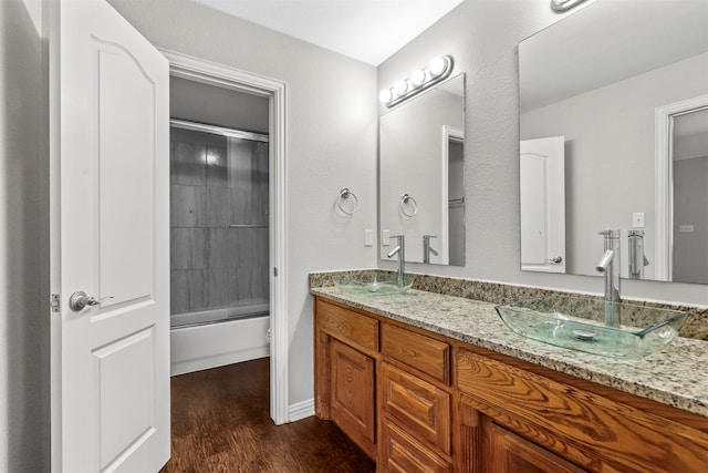 full bathroom featuring shower / bath combination with glass door, toilet, vanity, and hardwood / wood-style flooring