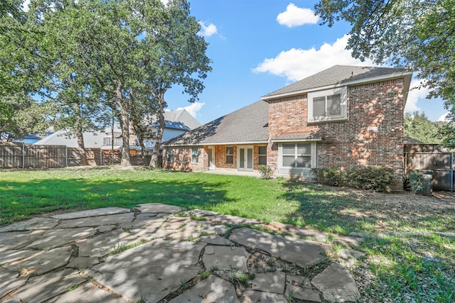 rear view of house with a lawn and a patio