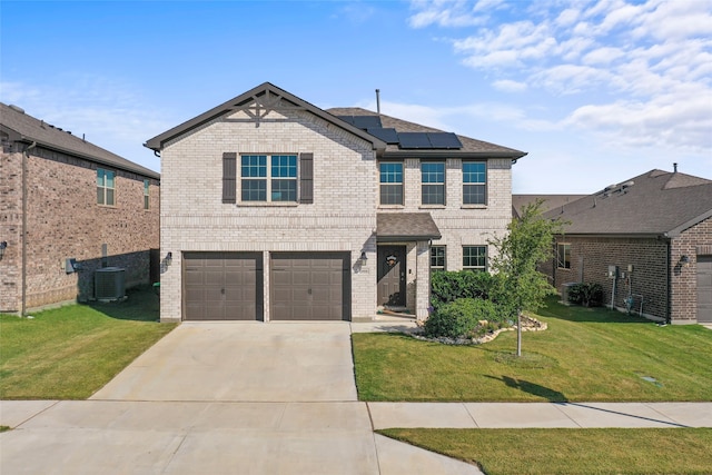 view of front of property with a garage, a front yard, and solar panels