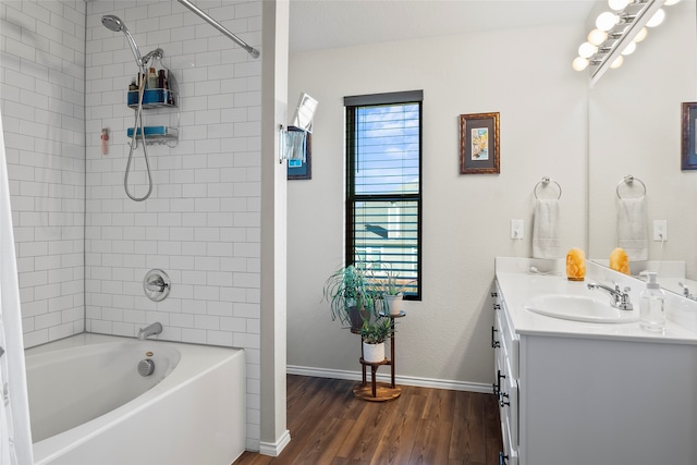 bathroom featuring hardwood / wood-style floors, vanity, and tiled shower / bath