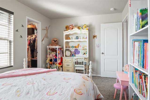 carpeted bedroom featuring a walk in closet and a closet