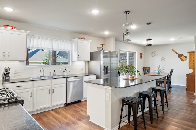 kitchen with white cabinets, decorative backsplash, sink, and appliances with stainless steel finishes