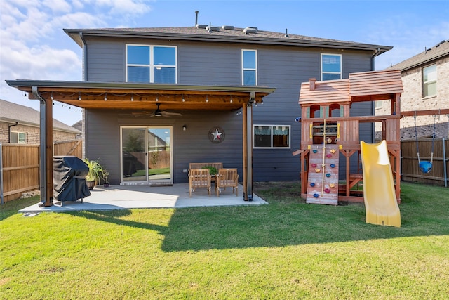 rear view of property featuring a yard, a playground, ceiling fan, and a patio area