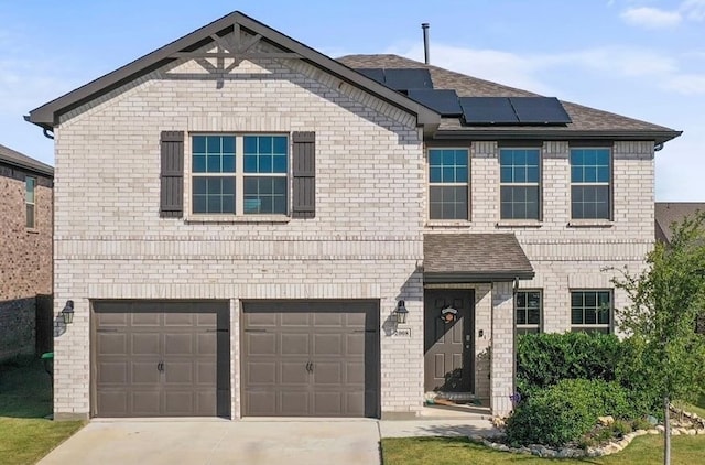 view of front property featuring a garage and solar panels