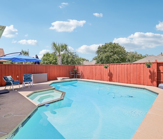 view of pool featuring an in ground hot tub, a diving board, and a patio