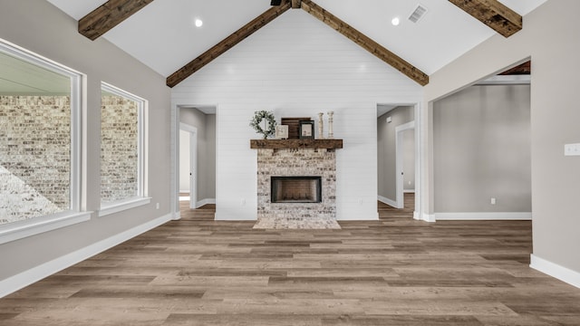 unfurnished living room with hardwood / wood-style flooring, beam ceiling, and high vaulted ceiling