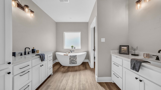 bathroom with vanity, hardwood / wood-style floors, and a tub