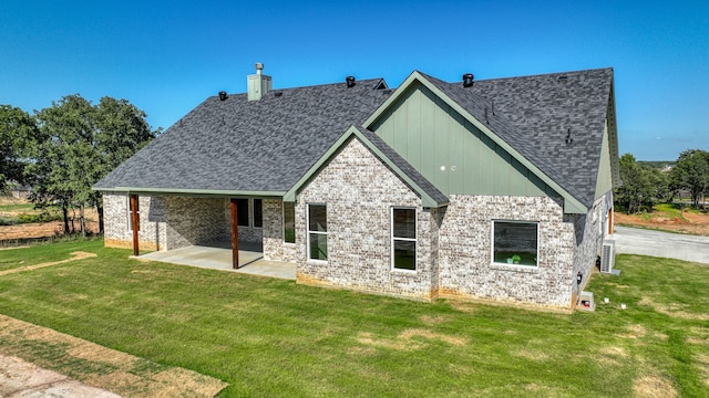 rear view of property featuring a lawn and a patio