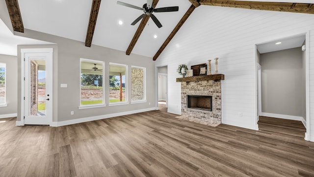 unfurnished living room with ceiling fan, hardwood / wood-style flooring, high vaulted ceiling, and a large fireplace