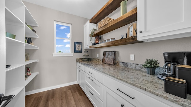 kitchen featuring white cabinetry, dark hardwood / wood-style floors, and light stone counters