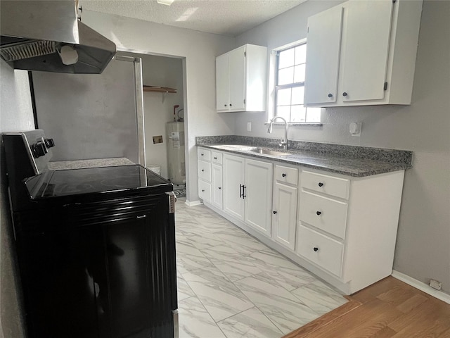 kitchen with electric water heater, under cabinet range hood, range with electric cooktop, a sink, and marble finish floor