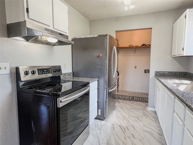 kitchen with appliances with stainless steel finishes, a textured ceiling, white cabinetry, and dark stone countertops