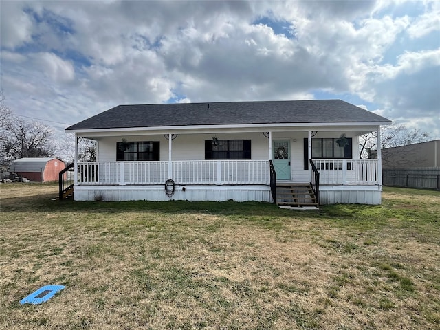 manufactured / mobile home featuring roof with shingles, a porch, and a front lawn