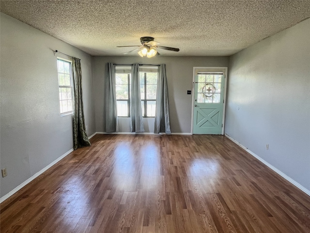 interior space featuring ceiling fan, dark hardwood / wood-style flooring, and a textured ceiling