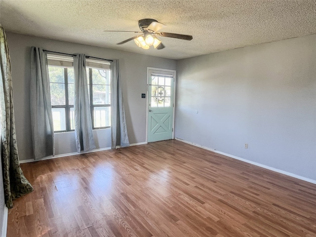 empty room featuring a textured ceiling, hardwood / wood-style flooring, and ceiling fan