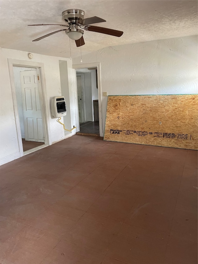 spare room featuring ceiling fan, heating unit, and a textured ceiling