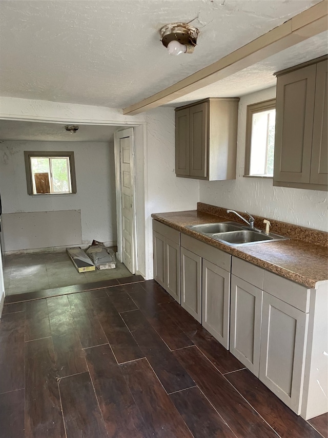 kitchen with gray cabinetry, a textured ceiling, sink, and dark hardwood / wood-style flooring