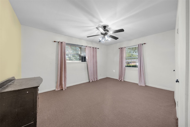 carpeted spare room with ceiling fan and plenty of natural light