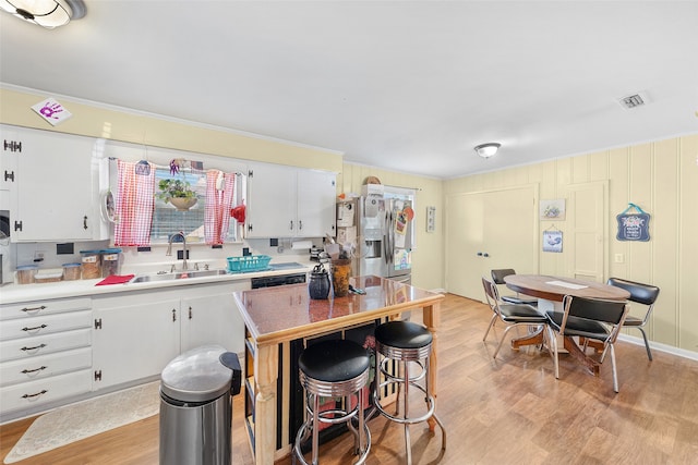 kitchen with white cabinets, a kitchen island, light hardwood / wood-style flooring, stainless steel refrigerator with ice dispenser, and sink