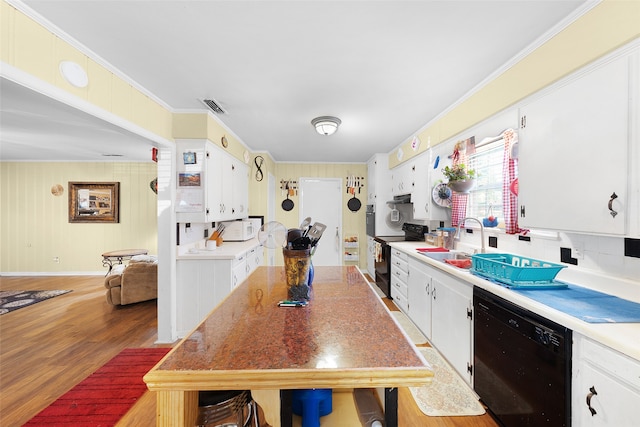 kitchen featuring hardwood / wood-style flooring, sink, white cabinetry, black appliances, and crown molding