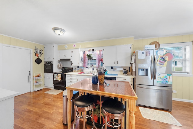 kitchen featuring light wood-type flooring, black appliances, white cabinetry, and sink