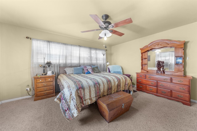 carpeted bedroom featuring multiple windows and ceiling fan